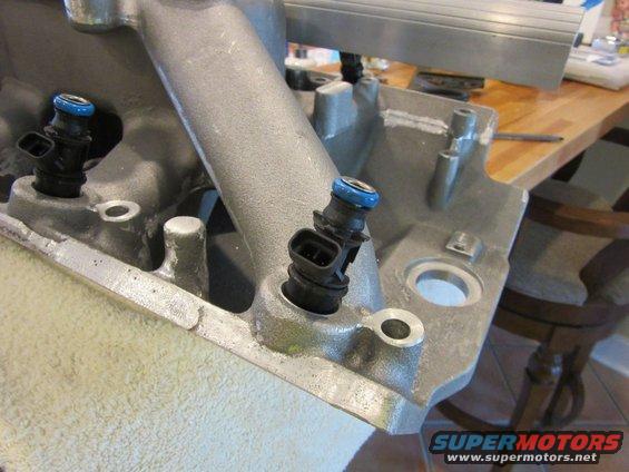 Close-up of fuel injectors mounted on a silver intake manifold