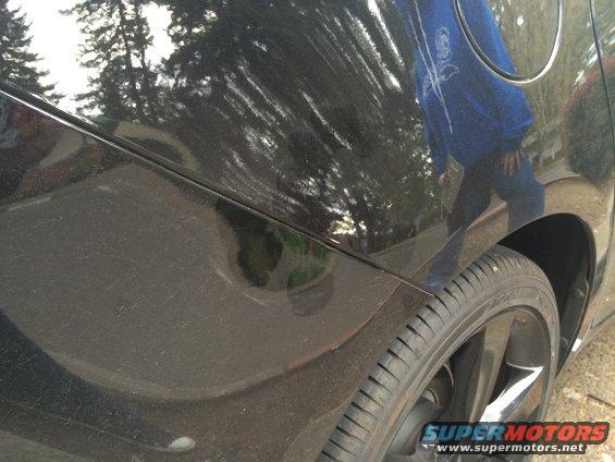 black car side panel, rear wheel, and part of the fender
