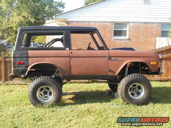 1972 Ford Bronco, lifted with custom brown and black paint, sitting in a grassy yard