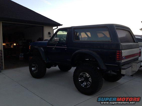 Dark blue lifted 1988 Ford Bronco, rear three-quarter view