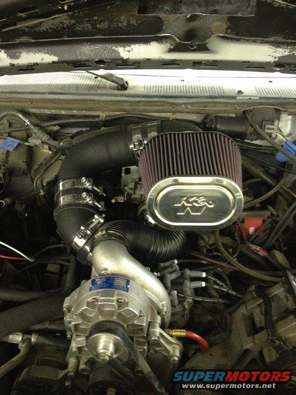 engine bay with K&N air filter, supercharger, and intake piping