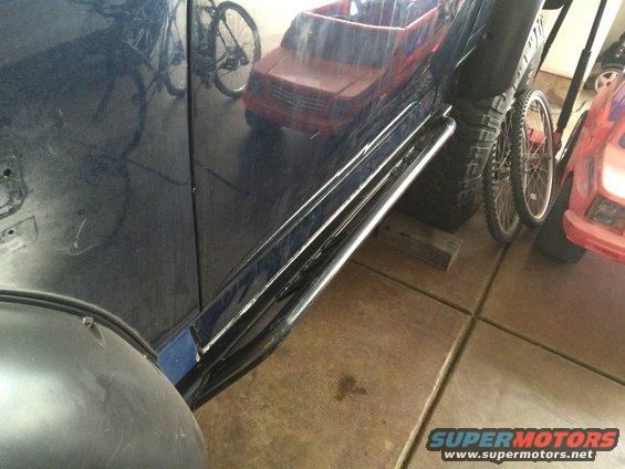 Dark blue SUV side view showing chrome rock sliders and a large tire