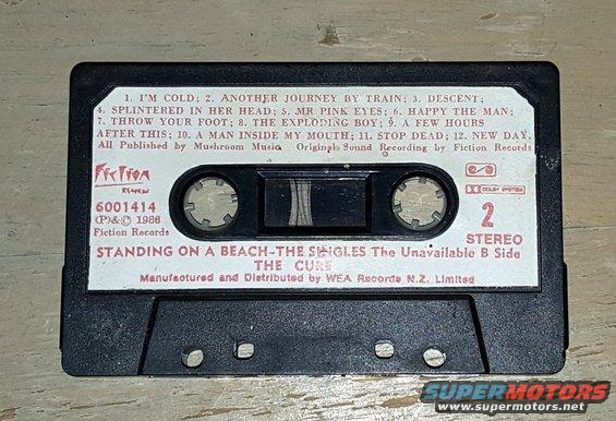 Cassette tape labeled 'STANDING ON A BEACH-THE SINGLES The Unavailable B Side THE CURE'
