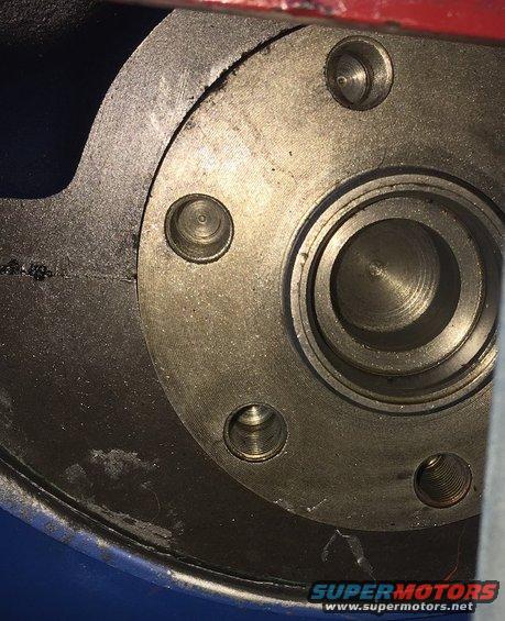 Close-up of an engine crankshaft flange with bolt holes