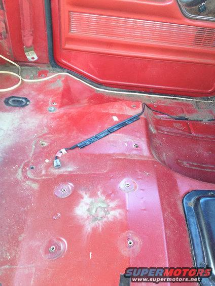 Red interior floor with exposed wiring and a red door panel above
