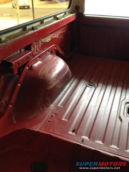 Red interior cargo area of a 1978 Ford Bronco, showing ribbed floor and wheel wells