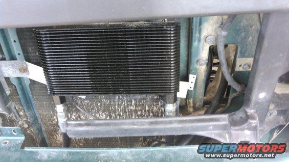 i have an finned oil cooler installed in front of the condenser behind the grill in a nice open spot. i fabricated some mounts to keep it well secured to the core support without rubbing the condensor. the cooler used female 1/2 inch NPT ports. i have the ports pointing downward for this setup

the hose on the right connects to the engine and is ran through a gap under and between the core support and the frame. it allowed me to flex the hose to come up vertically with no stress on the pipe.

the hose on the left is running to the remote oil filter. it is going left through the cutout of the core support on passenger side. there was plenty of room for the hose to be pointed vertically and flex with no stress

both hoses connecting to the cooler have swivels on these ends

the hose on the right through the cutout of the core support is not connected to the cooler. it is running form the engine to the remote oil filter. it runs to the other side cutout

