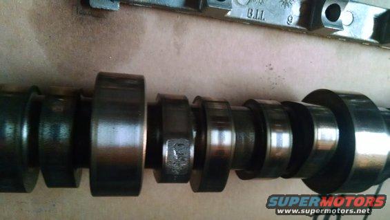 Camshaft with multiple lobes and bearing journals. Text 'B.I.I.' and '9' visible