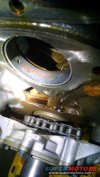 close-up of engine timing chain and gears with oil