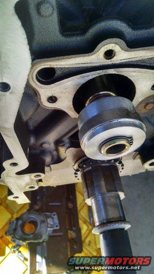 Engine part with tool inserted, Supermotors.net logo visible