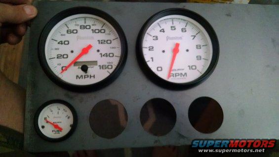 Phantom brand speedometer, tachometer, and fuel gauge mounted on a metal panel