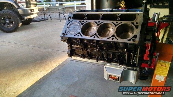 Engine block on a stand next to a pickup truck
