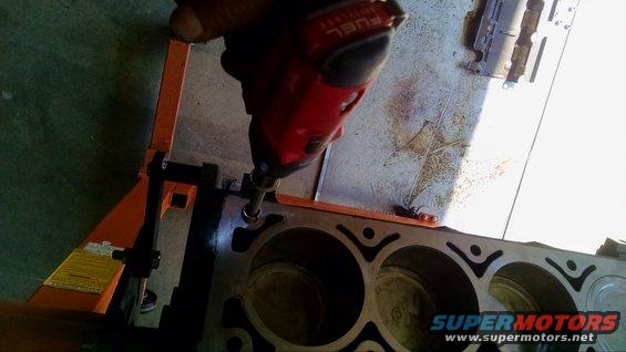 Impact driver working on an engine block. Engine block has cylinder cutouts