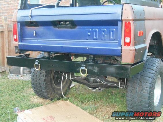 Rear chassis and large tires of a pickup truck, viewed from behind