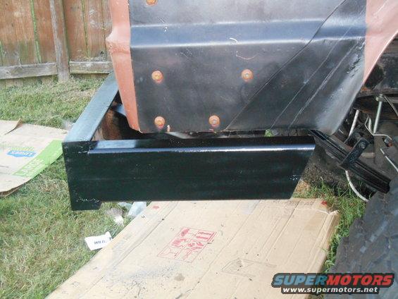 close-up of a black metal step and body panel on a vehicle, possibly undergoing repair