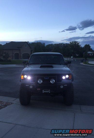 Front view of a lifted SUV with aftermarket bumper, winch, and auxiliary lights