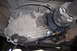 1990 Ford Bronco - Underside view of a vehicle's transfer case and driveshaft, showing signs of oil leakage.