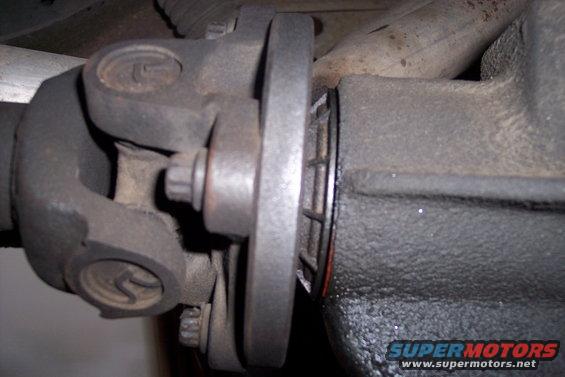 Driveshaft U-joint connected to differential flange with visible Supermotors.net logo