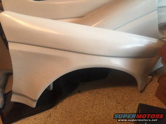 White car fender with gray trim lines, viewed from the side