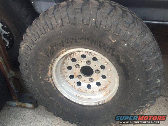 Close-up of a large off-road tire mounted on a multi-hole aluminum wheel