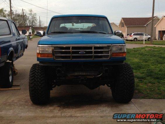 Front view of a lifted blue 1995 Ford Bronco with large tires