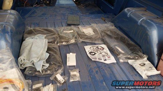 Interior of a blue vehicle with parts and supplies laid out.