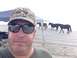 1979 Ford Bronco - A man takes a selfie on the beach as a group of horses walks past in the background.