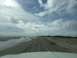 1979 Ford Bronco - Driving on a beach with tire tracks and clouds overhead.