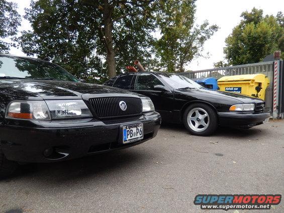 Front of a black Mercury Marauder next to another black sedan