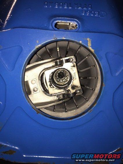 Close-up of a blue metal housing with a circular opening revealing internal mechanical components, possibly a clutch or brake assembly