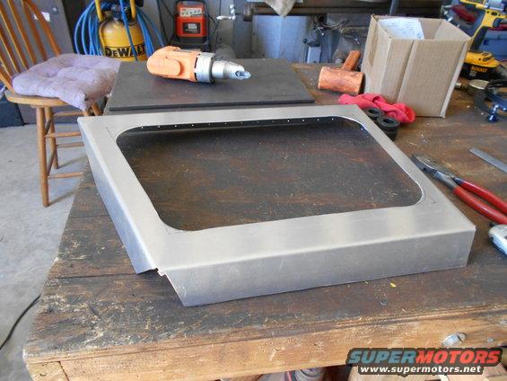 metal frame with cutout on workbench, tools nearby