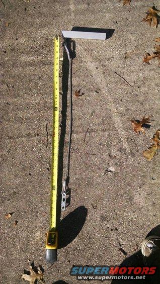 Yellow tape measure next to a metal bracket on concrete