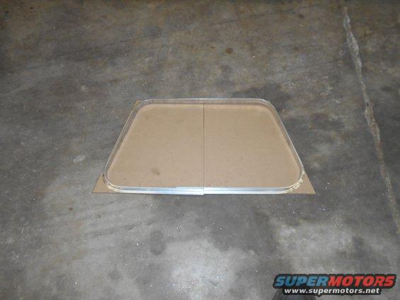 Window frame with cardboard backing on concrete floor