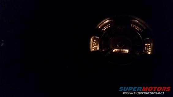 Illuminated dashboard gauge cluster in darkness