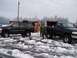 1998 Ford Expedition - Two black vehicles, an SUV and a pickup truck, are parked in a snowy area with several individuals in military uniforms nearby.