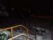 1998 Ford Expedition - Nighttime scene with snow covering the ground and bushes, illuminated by distant lights.