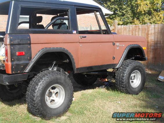 Brown Ford Bronco with black hardtop, lifted suspension, and large off-road tires