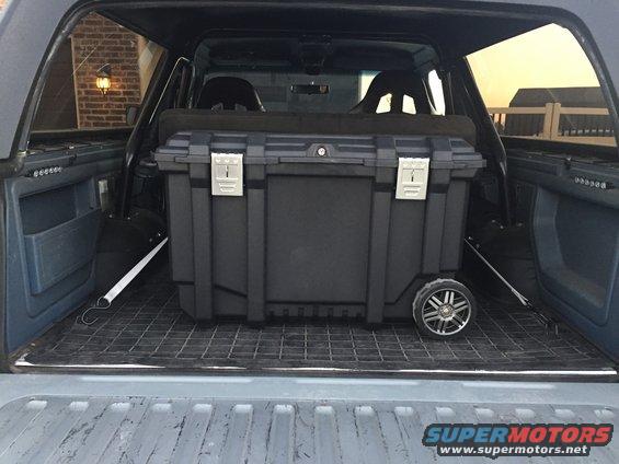 1988 Ford Bronco interior showing a large black storage box with wheels in the cargo area
