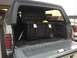 1988 Ford Bronco - Rear view of a 1988 Ford Bronco showing the cargo area with a large storage container inside.