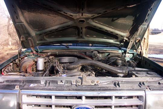 1987 Ford Bronco engine bay with hood open, showing engine components and wiring
