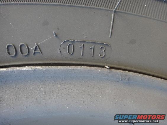 Close-up of tire sidewall showing DOT code 0113, indicating manufacture in the first week of 2013