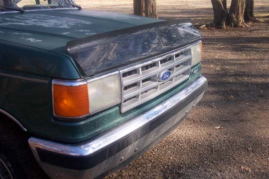 Green 1987 Ford Bronco front grille with chrome bumper and amber turn signal