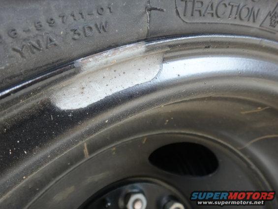 Close-up of tire sidewall with DOT code YNA 3DW and part of a black steel wheel