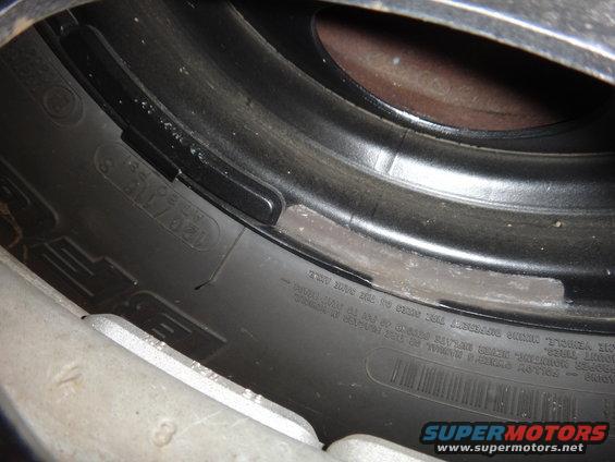 Close-up of a tire sidewall with size information and wheel rim