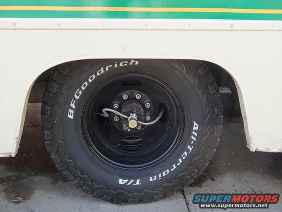 BFGoodrich All-Terrain T/A tire on a black dually wheel with a chrome valve stem extender