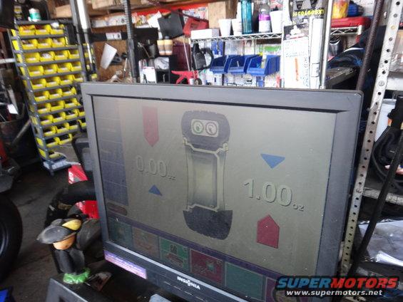 Tire balancing machine display showing 0.00 oz and 1.00 oz readings
