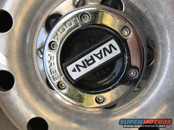 Chrome WARN manual locking hub with LOCK/FREE markings on a polished aluminum wheel