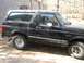 1994 Ford Bronco - Side profile of a black 1994 Ford Bronco, showing its distinctive body style and removable hardtop.