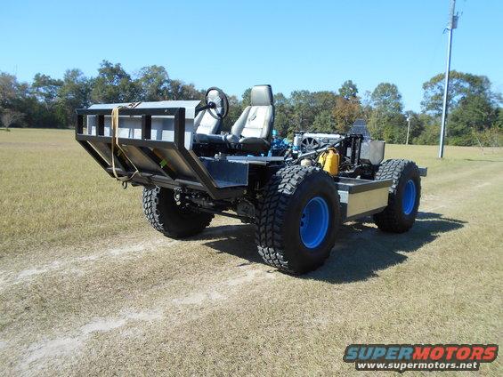 Custom off-road vehicle with two seats, open rear bed, and large tires