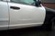 2001 Ford Crown Victoria - This police car has a dent on its white door panel. The rear fender is painted black.